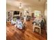 Open living room with wood laminate flooring, neutral walls, floral chairs, and a view into a bright office space at 33818 Venice Ln, Sorrento, FL 32776