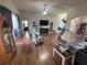 This living room has wood floors, furniture, a tv, and access to other rooms at 33818 Venice Ln, Sorrento, FL 32776