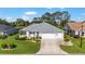 An elevated view of a well-maintained home featuring a gray roof, green lawn, and attached three car garage at 3393 Talley Ridge Dr, The Villages, FL 32162
