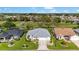 An elevated shot showcases a charming home near a golf course with lush landscaping at 3393 Talley Ridge Dr, The Villages, FL 32162