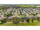 High-angle aerial of a picturesque neighborhood showcasing manicured lawns, tree-lined streets, and golf-course view at 3393 Talley Ridge Dr, The Villages, FL 32162