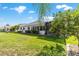Backyard featuring lush green grass, mature trees, and access to a screened-in lanai at 3393 Talley Ridge Dr, The Villages, FL 32162