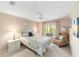 Serene bedroom featuring a patterned comforter and an armchair with a large window looking out to trees at 3393 Talley Ridge Dr, The Villages, FL 32162