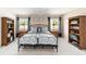 Comfortable bedroom with ceiling fan, bookshelves, and two large windows with view at 3393 Talley Ridge Dr, The Villages, FL 32162