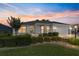 Charming single-story home with well-manicured lawn and hedges under a vibrant sunset sky at 3393 Talley Ridge Dr, The Villages, FL 32162