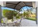 Enclosed lanai showcasing outdoor seating, a table, and scenic backyard views at 3393 Talley Ridge Dr, The Villages, FL 32162