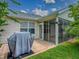Backyard patio, lawn, and enclosed lanai with table set with seating for four at 3432 Fairfield St, The Villages, FL 32162