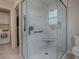 Modern bathroom featuring a glass enclosed shower with floor-to-ceiling tile and a window at 3432 Fairfield St, The Villages, FL 32162