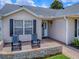 Inviting front porch featuring cozy rocking chairs and a charming brick accent wall at 3432 Fairfield St, The Villages, FL 32162