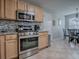 Well-equipped kitchen with stainless steel range, microwave, and adjacent dining area at 3432 Fairfield St, The Villages, FL 32162
