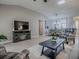 Open-concept living room featuring luxury vinyl plank flooring, a modern media center, and comfortable seating at 3432 Fairfield St, The Villages, FL 32162