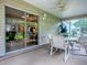 Enclosed lanai with dining table, ceiling fan and large sliding doors opening up to backyard at 3432 Fairfield St, The Villages, FL 32162