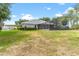 Exterior of the home showcasing the screened pool, carport, and spacious yard at 36455 Clara St, Eustis, FL 32736