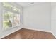 Bedroom with hardwood floors, bright window with blinds, and freshly painted white walls at 36455 Clara St, Eustis, FL 32736