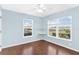 Light blue bedroom featuring two windows, hardwood floors, and shelving at 36455 Clara St, Eustis, FL 32736