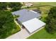Well-maintained home with a grey roof, carport, and a partially screened pool at 36455 Clara St, Eustis, FL 32736