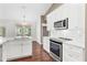 Bright kitchen features white cabinets, stainless steel appliances, subway tile backsplash and island with sink at 36455 Clara St, Eustis, FL 32736