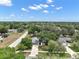 Aerial view of the home showcasing the surrounding neighborhood, mature trees, and blue skies at 36482 Doral Dr, Grand Island, FL 32735