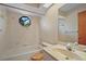 This bathroom features a sink, bathtub, octagonal window with view of the outdoors, and patterned tile at 36482 Doral Dr, Grand Island, FL 32735