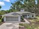 Charming single-story home with a well-maintained lawn and two-car garage, nestled under mature trees at 36482 Doral Dr, Grand Island, FL 32735