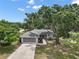 Aerial view of a single-story home with mature trees, a two-car garage, and a manicured lawn at 36482 Doral Dr, Grand Island, FL 32735