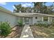 Inviting front entrance with a well-lit walkway, decorative landscaping, and unique architectural details at 36482 Doral Dr, Grand Island, FL 32735