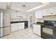 Bright kitchen features white cabinets, stainless steel refrigerator, and black countertops at 36482 Doral Dr, Grand Island, FL 32735