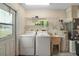 Bright laundry room with washer, dryer, utility sink, shelving, and water heater, with access to the outside at 36482 Doral Dr, Grand Island, FL 32735