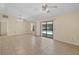 A bright living room with tile flooring and ceiling fans has a sliding glass door to a pool at 36482 Doral Dr, Grand Island, FL 32735