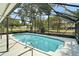 Screened in pool featuring a clean design, stainless steel ladders, and ample space for entertaining at 36482 Doral Dr, Grand Island, FL 32735