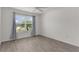 Bedroom boasts neutral walls, vinyl flooring, and a window overlooking lush greenery at 3745 Causey Ct, The Villages, FL 32163
