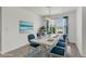 Staged dining room with blue accents, ocean artwork and modern light fixture at 3745 Causey Ct, The Villages, FL 32163