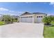 Home exterior featuring a three-car garage, a paved driveway, and verdant landscaping at 3745 Causey Ct, The Villages, FL 32163