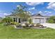 Inviting single-story home featuring a lush green lawn and attractive landscaping leading to the front entrance at 3745 Causey Ct, The Villages, FL 32163