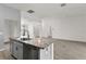 Open kitchen and living room with gray cabinets, a kitchen island, and sleek flooring at 3745 Causey Ct, The Villages, FL 32163