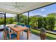Staged screened lanai with dining table and chairs and outdoor view of lush green landscaping at 3745 Causey Ct, The Villages, FL 32163
