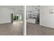 Open-concept living room with wood-look floors, lots of light, and open view to the kitchen at 3745 Causey Ct, The Villages, FL 32163