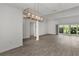 Bright living room with sliding glass doors to lanai, ceiling fan, and views into dining room and kitchen at 3745 Causey Ct, The Villages, FL 32163