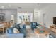 Staged living room with hardwood floors, living room seating, and views of the dining and kitchen at 3745 Causey Ct, The Villages, FL 32163