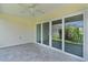 Covered patio with tile flooring and sliding glass doors to backyard at 3745 Causey Ct, The Villages, FL 32163