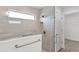 Modern glass shower enclosure with beige tiled walls and a slim horizontal window at 3745 Causey Ct, The Villages, FL 32163