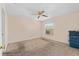 This bedroom includes carpeted floors, a ceiling fan, and a window with a view of the property at 403 Duarte Ln, The Villages, FL 32159