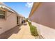 This exterior view shows a walkway between homes with landscaping and outdoor awnings at 403 Duarte Ln, The Villages, FL 32159