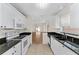 Bright kitchen featuring white cabinets, black granite countertops, and modern appliances at 403 Duarte Ln, The Villages, FL 32159