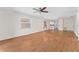 Open-concept living room featuring hardwood flooring, natural light, and a ceiling fan for added comfort at 403 Duarte Ln, The Villages, FL 32159