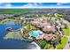 Aerial view of a luxurious community with a pool, clubhouse, lake, and lush landscaping at 503 Vigo St, Davenport, FL 33837