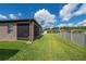 View of the backyard, including a screened in porch and white fence at 503 Vigo St, Davenport, FL 33837