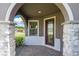 Charming front entrance with stone accents, a decorative glass door, and a brick-paved walkway, inviting you into a warm home at 503 Vigo St, Davenport, FL 33837