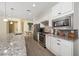 Stylish kitchen featuring stainless steel appliances, granite countertops, a tiled backsplash, and modern white cabinetry at 503 Vigo St, Davenport, FL 33837