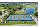 Beautifully maintained tennis courts in a community with palm trees, lake, and surrounding greenery at 503 Vigo St, Davenport, FL 33837